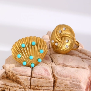 Close-up of vintage gold shell ring with blue bead and rhinestone twist ring