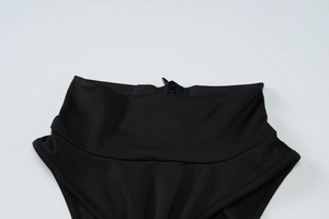 Detailed view of the sleek black zipper and fine stitching on the high-waist dress