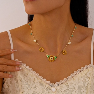 Detail of sunflower and bee necklace with colorful enamel charms on model neck