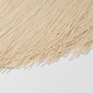 Detailed close-up of shiny golden textile tassels on a halter fringe mini dress