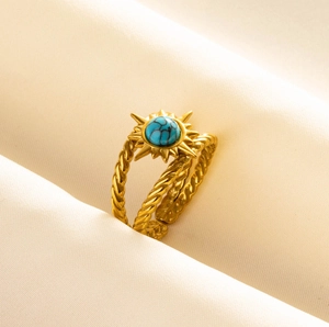 Detail of adjustable gold sunburst ring with turquoise stone and twisted band design