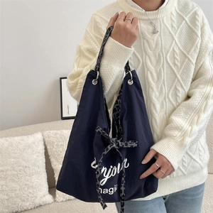 Detail of navy canvas tote bag with leopard print handles and Bonjour magic text