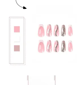 Detailed view of pink and white press-on nails with glitter, rhinestones, and French tips