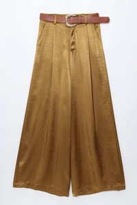 Detailed macro view of gold satin wide leg trousers with a brown belt and metal buckle