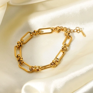 18K gold plated wide chain link bracelet in stainless steel on a soft silk background