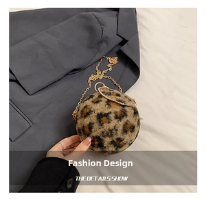 Close-up of leopard print plush sphere bag with a gold ring handle on a blue blazer