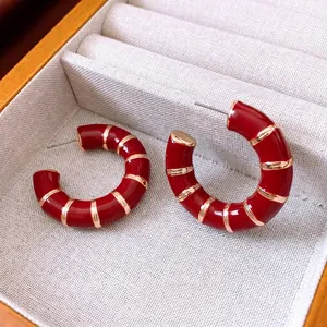 Retro red enamel C-shaped hoop earrings with gold stripes in a luxury jewelry box