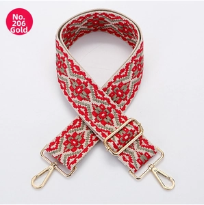 Close-up of thick canvas bag strap with red and grey ethnic geometric pattern and gold hooks