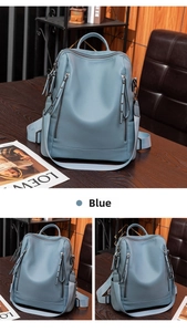 Detail view of dusty blue pebble leather backpack with vertical zippers and soft texture