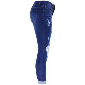 Detail view of high-waist blue distressed jeans with frayed holes and whisker wash