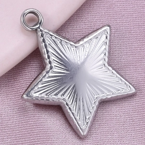 Detailed view of silver star pendant with sunburst texture and small metal loop