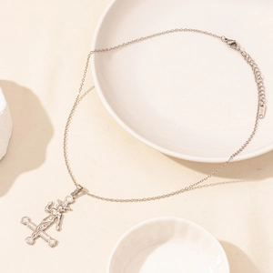 Detailed macro view of silver stainless steel inverted cross pendant with figure relief