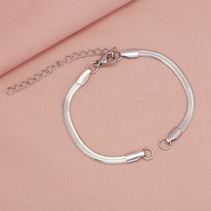 Dettaglio di un bracciale a catena serpente argento con chiusura a moschettone rosa
