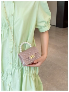Detail of pink jelly handbag with pearl handle and diamond lattice texture