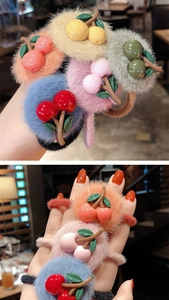 Dettaglio di simpatici elastici per capelli a ciliegia in peluche in vari colori