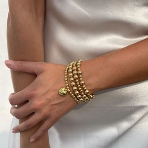 Bohemian gold beaded bracelet set with heart pendant and multilayered polished design