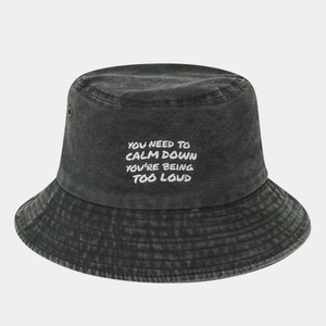 Close-up of washed black denim bucket hat with white text embroidery and metal eyelets