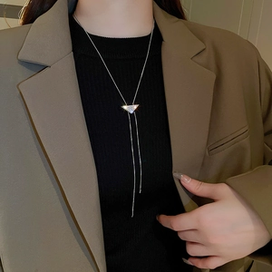 Detail view of a silver sliding sweater necklace with a diamond-set triangle pendant