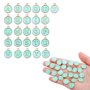 Detailed view of mint green enamel letter charms with rose gold edges for DIY jewelry