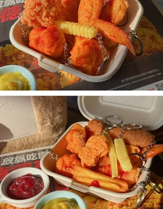 Close-up of realistic PVC fried chicken and fries food keychain models with metal rings