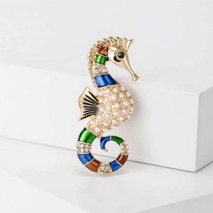 Golden seahorse brooch with multicolored enamel, white pearls, and sparkling rhinestones
