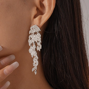 Close-up of model wearing silver leaf tassel earrings with sparkling zircon crystals