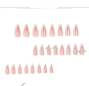Détail d'ongles ballerine roses avec dégradé pailleté argenté et papillon métallique en 3D