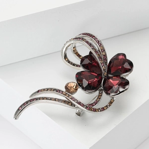 Elegant silver four-leaf clover brooch with sparkling red and pink rhinestones