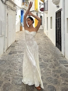 Elegant white spaghetti strap maxi dress with textured floral embroidery on white street