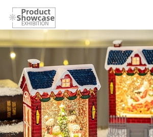 Close-up of a lit Christmas snow globe house with a snowman and a Santa figurine inside