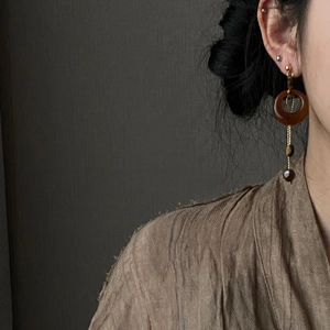 Detail of amber tiger eye drop earring on model showcasing the retro resin texture