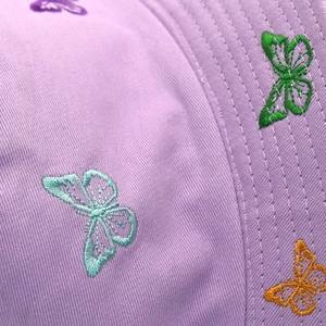 Close-up of vibrant butterfly embroidery on premium lilac cotton twill sun hat fabric
