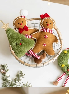 Detailed close-up of plush gingerbread man and Christmas tree hanging ornaments in a basket