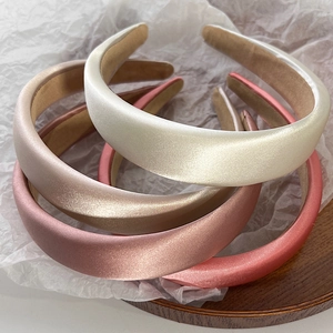 Elegant satin padded headbands in assorted pastel colors including cream and champagne gold