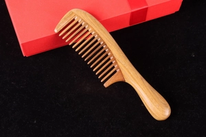 Macro detail of high-quality green sandalwood comb with natural wood grain and thick round handle