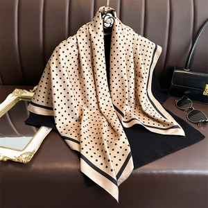 Seidentuch mit Polka-Dots in Beige und Schwarz, hängend mit modischem Outfit präsentiert