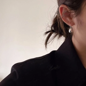 Minimalist 925 sterling silver teardrop earring worn by a model in a side view profile