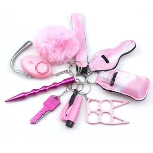Pink self-defense keychain kit with alarm, wristlet, and lipstick holder on white background