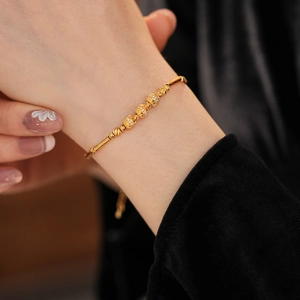 Close-up of 18K gold plated bamboo bracelet with zircon studded hollow beads on wrist