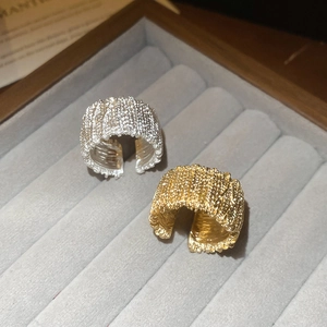 Detailed macro view of textured gold and silver adjustable rings on velvet display