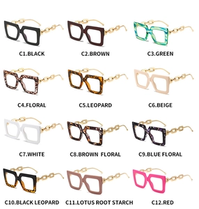 Grid view of stylish oversized glasses frames in twelve vibrant colors with gold chain temples