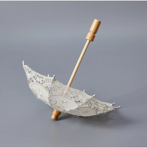 Detailed view of white floral lace embroidery and premium wood handle on bridal umbrella