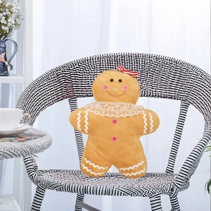 Detail of gingerbread man plush pillow with lace collar on a striped chair decoration