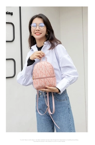 Detail of pink mini backpack featuring lucky letter prints and golden metal zippers