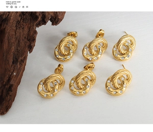 Detail of three pairs of gold double-hoop earrings with twisted texture and zircon inlay