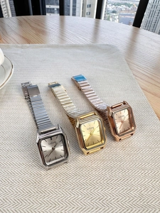 Close-up of rectangular quartz watches in silver, gold, and rose gold with steel bands
