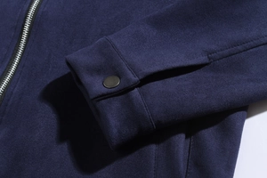 Detail of navy faux suede jacket featuring metal zipper and snap button cuff