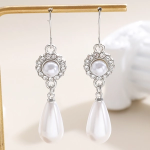 Macro di orecchini a goccia con perle e fiori di strass su supporto dorato elegante