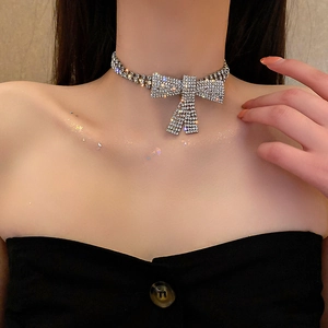 Nahaufnahme des eleganten silbernen Chokers mit Strass-Schleife auf dem Schlüsselbein