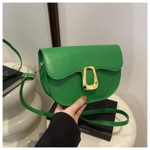 Detail of green PU leather shoulder bag featuring a unique irregular trapezoid gold buckle